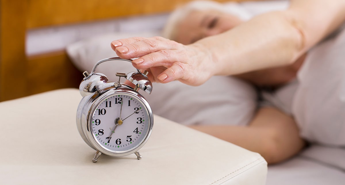 Hand hitting an alarm due to parkinson's sleep disorders