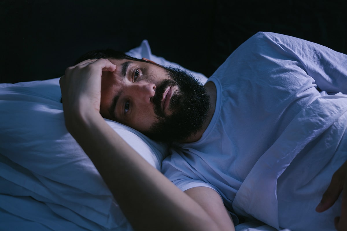 Man laying in bed suffering from parkinsons and sleep disturbances