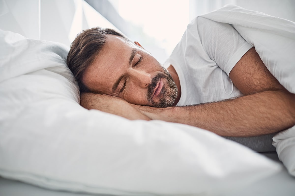 Man laying in bed with good sleep quality