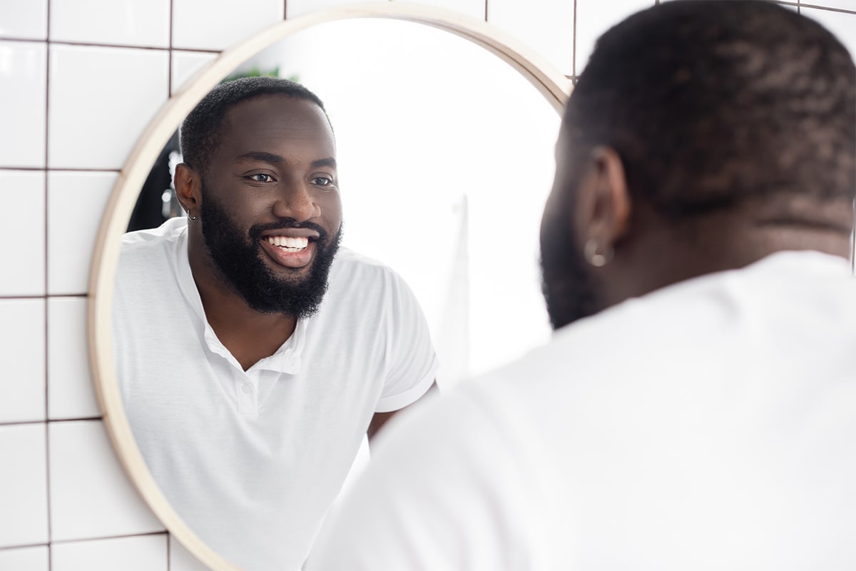 A caregiver looking in the mirror as he starts his day of being a care partner