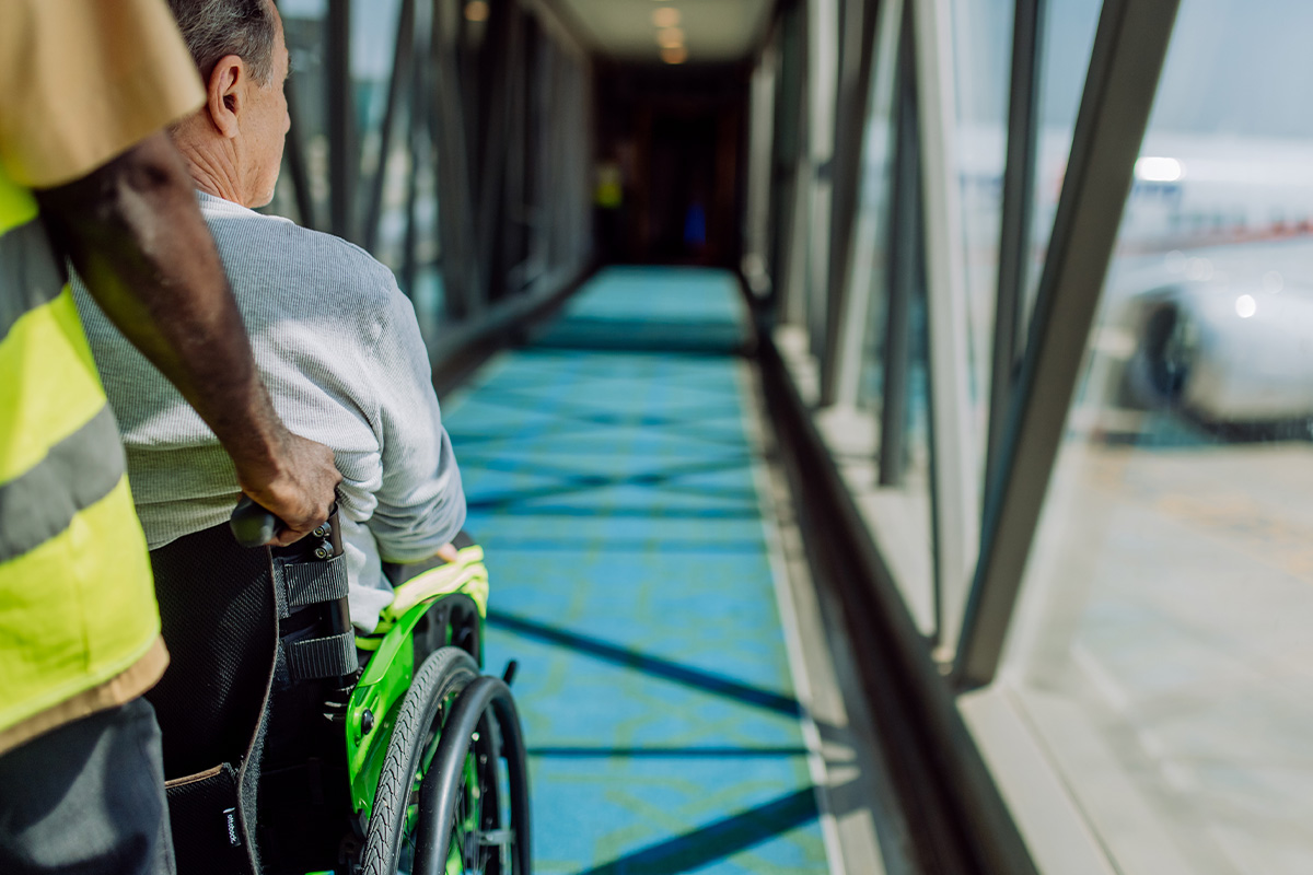 Man getting escorted by wheelchair in the airport