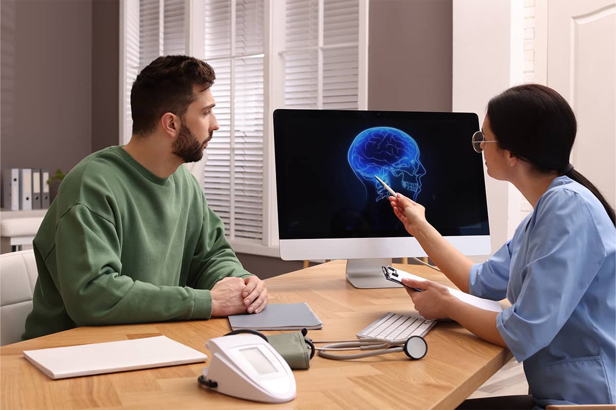 Neurologist showing brain scan to a man living with Parkinson's disease