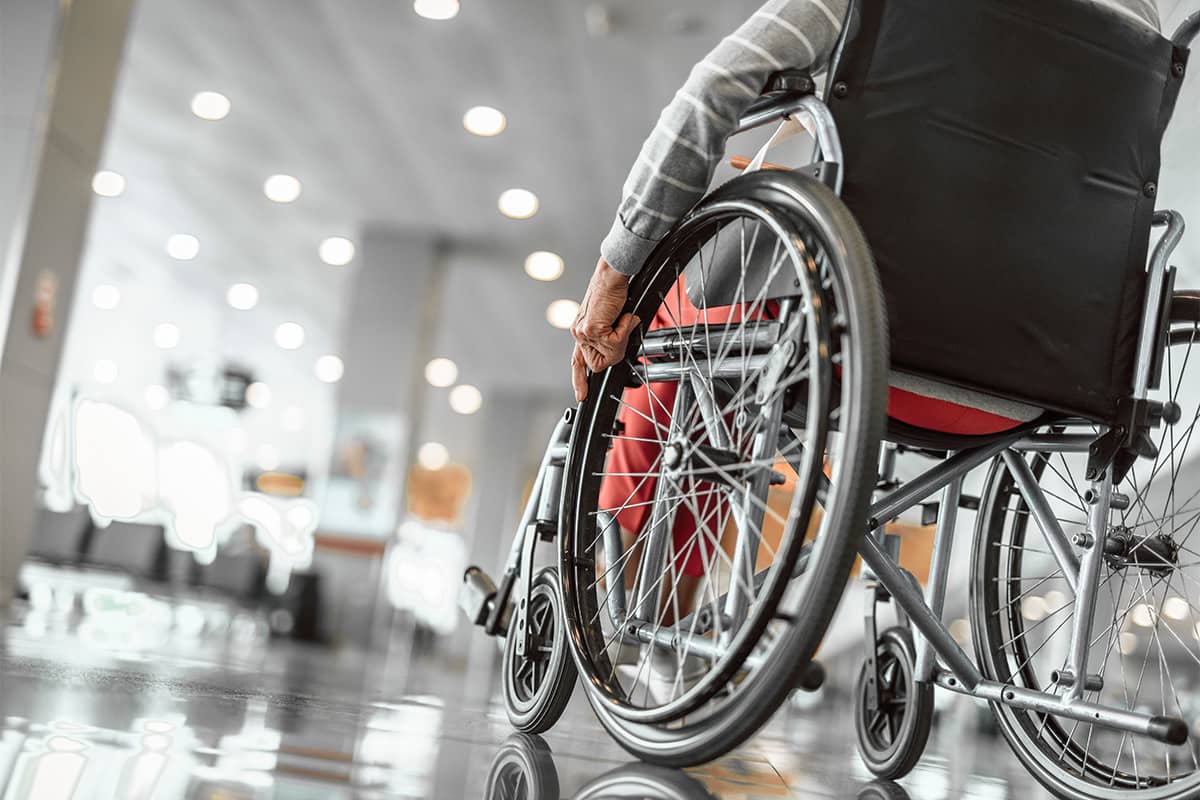 Person with Parkinson's in a wheelchair at an airport