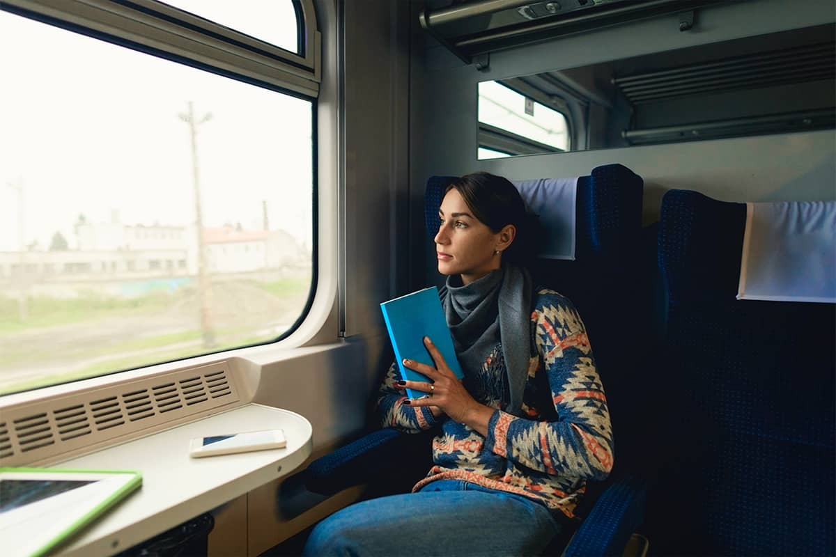 Woman with Parkinson's traveling by train sitting near window