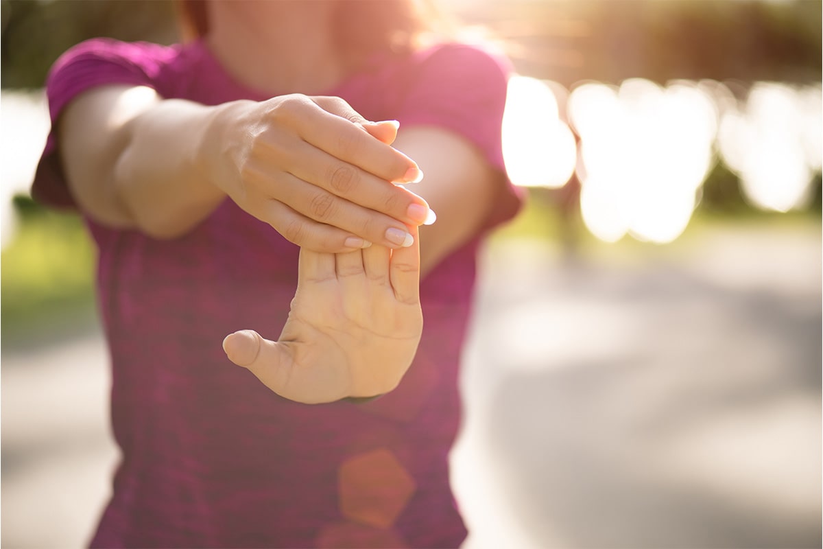 A woman stretching her hands out to alleviate Parkinson's symptoms