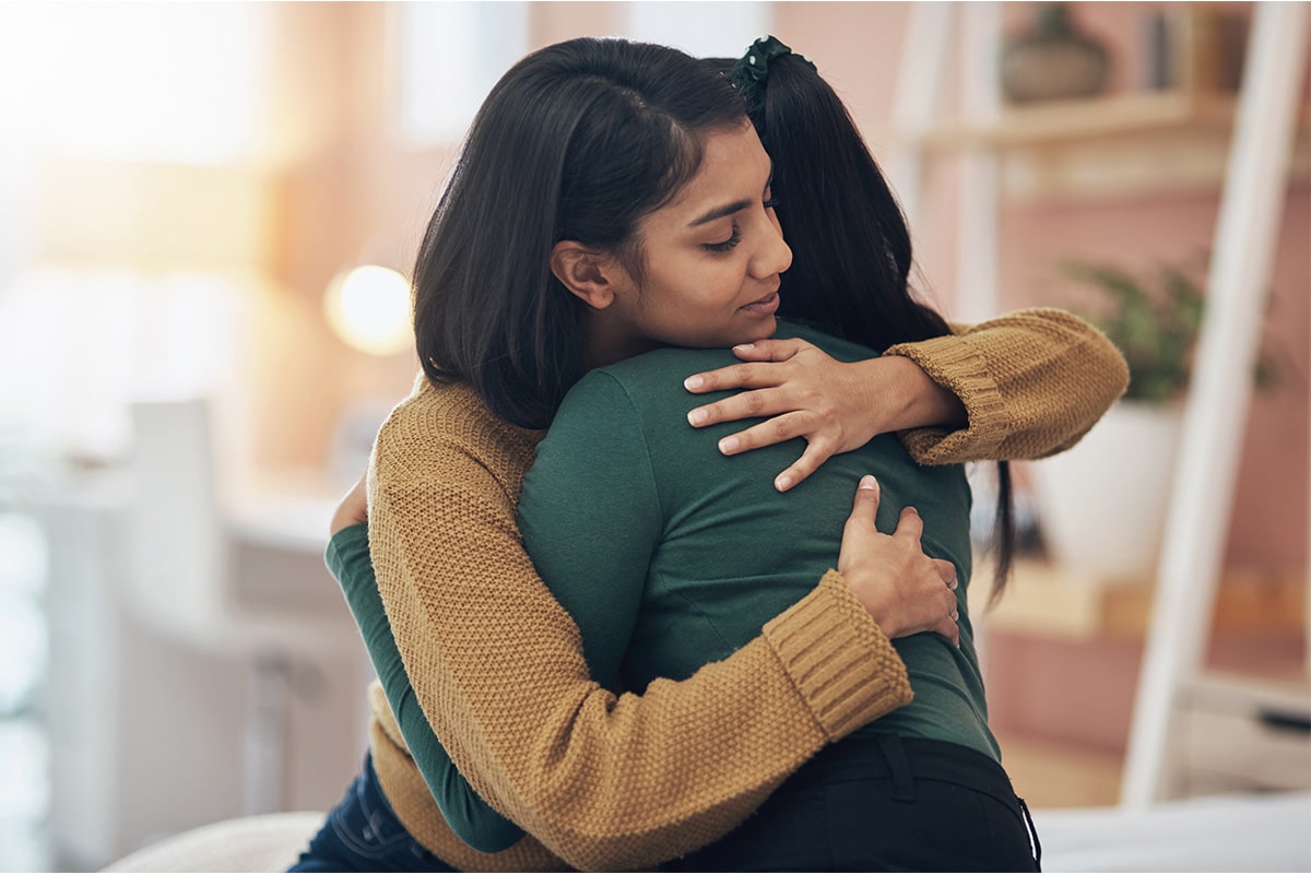 Two woman hugging one another to show comfort after sharing about their Parkinson's diagnosis