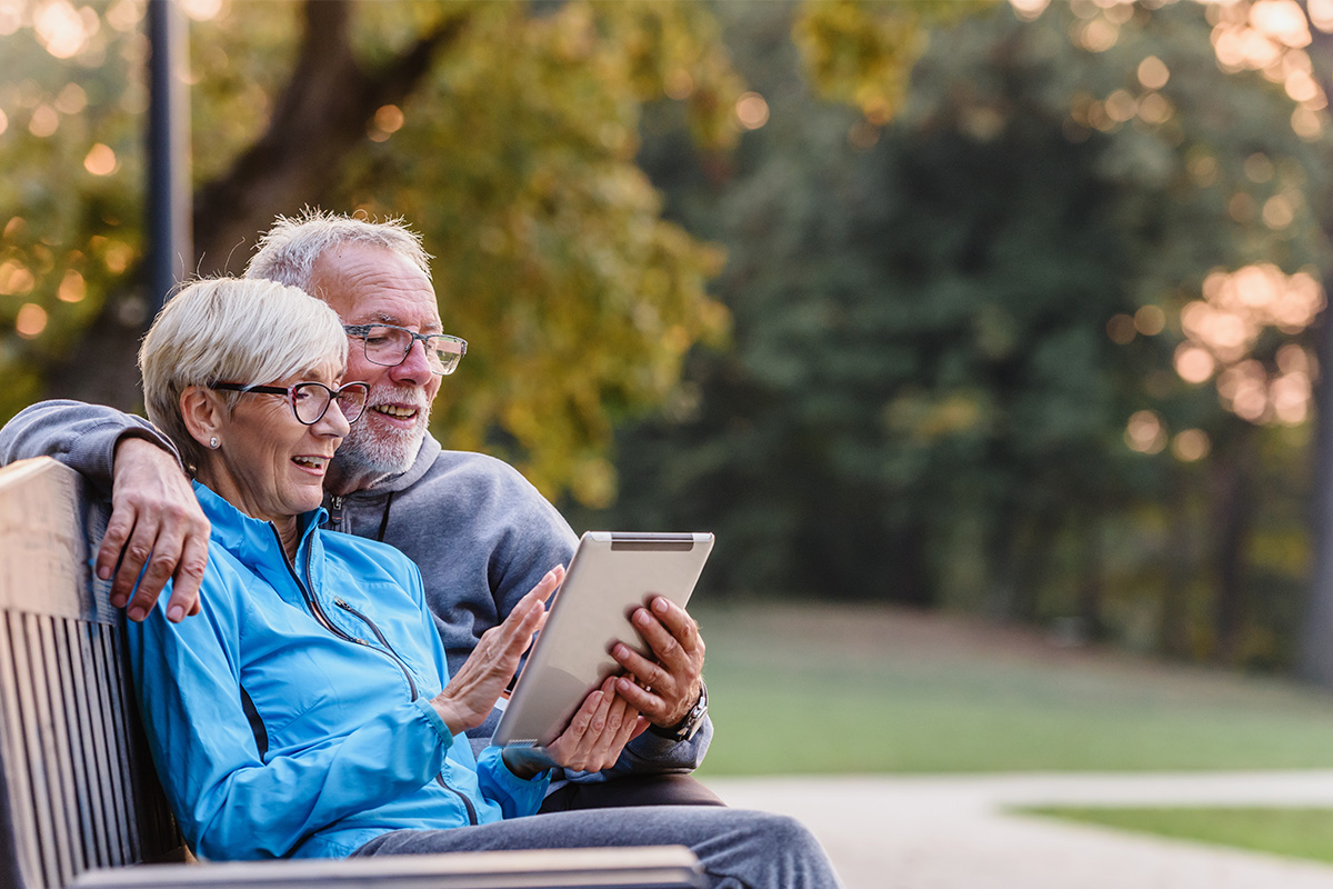 Couple on a park bench looking at an iphone