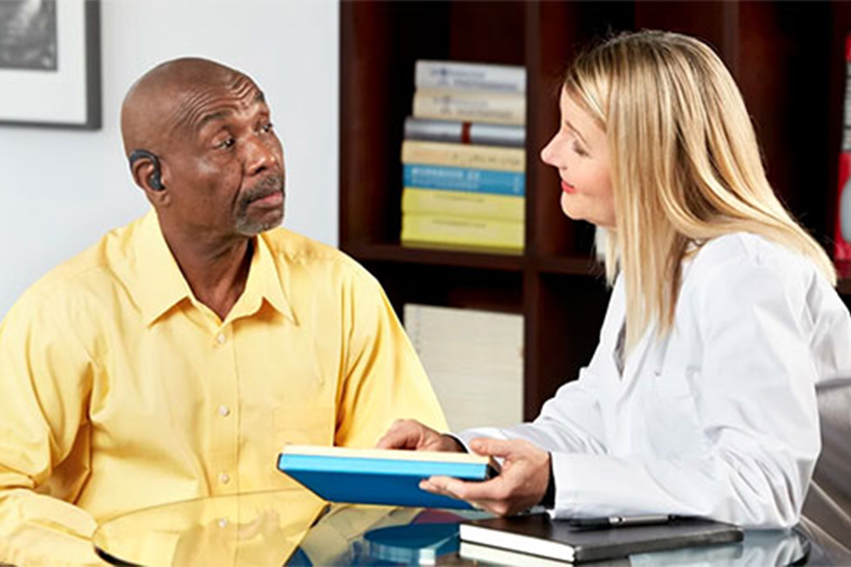 man at a doctor office talking about hearing aids