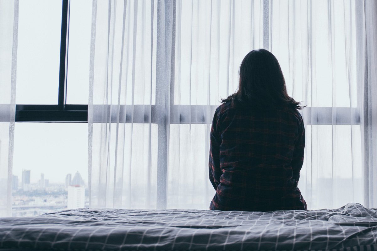 Depressed woman sitting on a bed