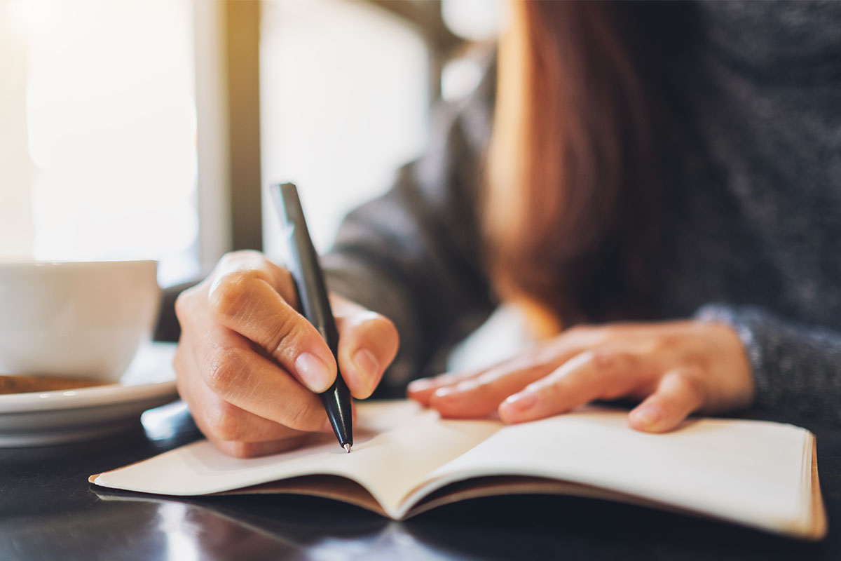 Person writing in a gratitude journal