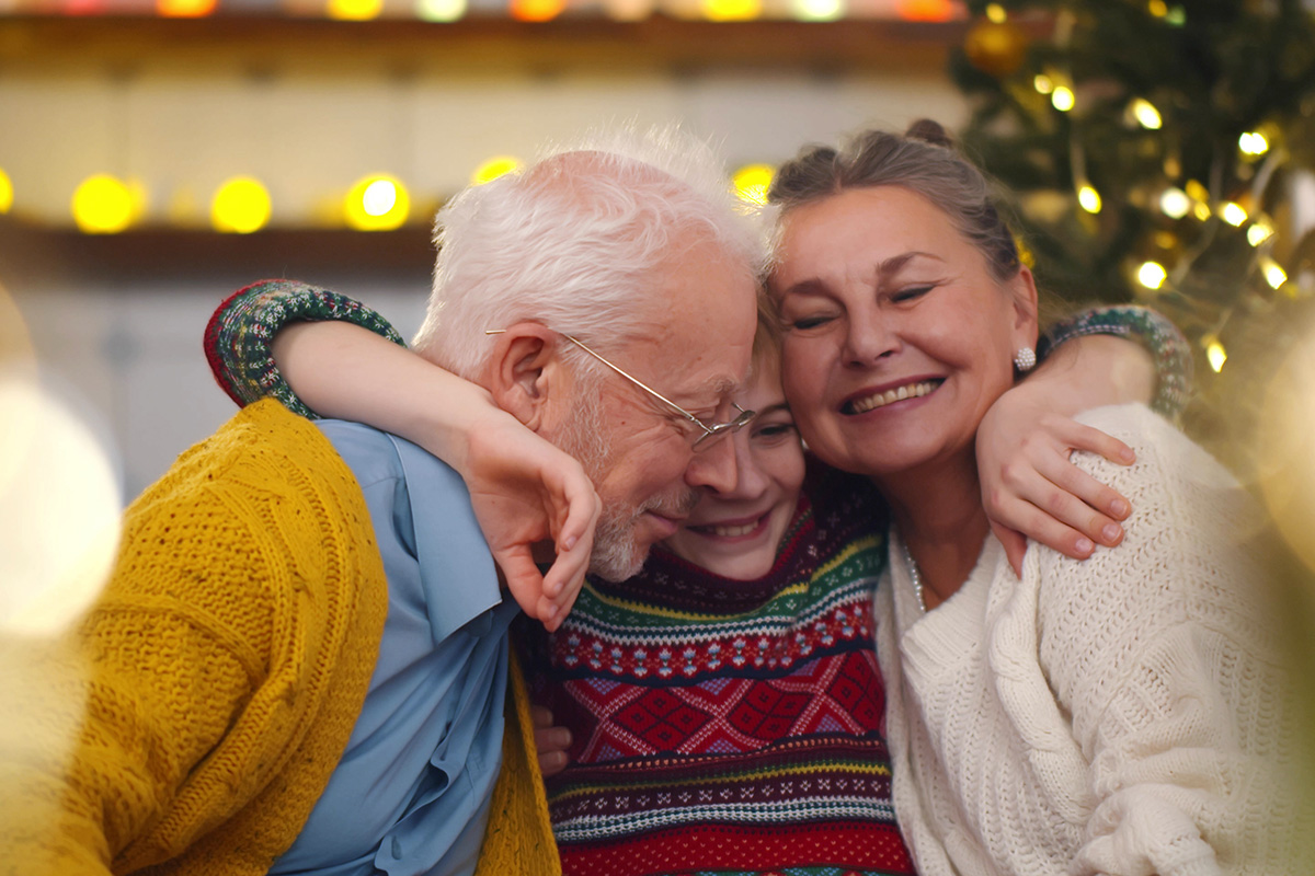 Grandkid hugging grandparents on christmas